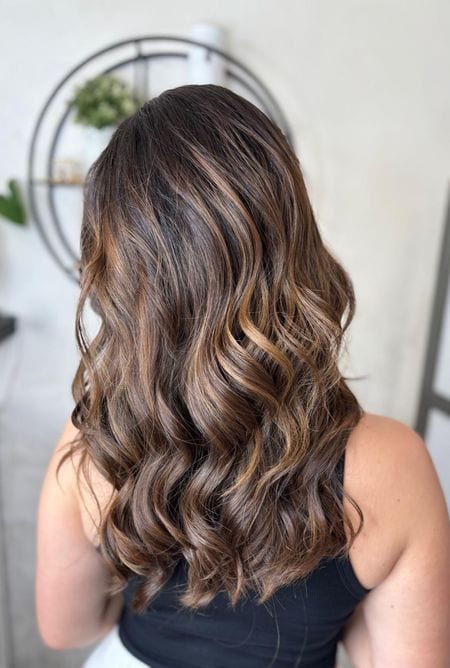 Capelli lunghi mossi castani con riflessi caramello